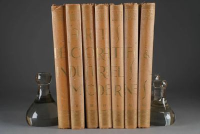 Plusieurs livres sont empilés les uns sur les autres à côté d'un vase en verre