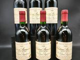 six bouteilles de vin sont alignées sur une table