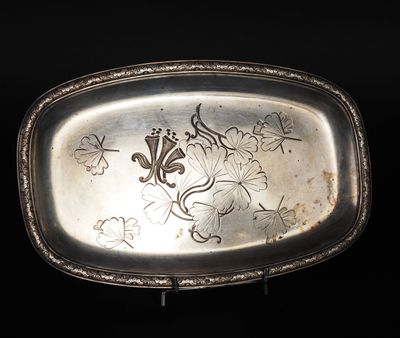 une assiette en argent ornée d'un motif sur fond noir