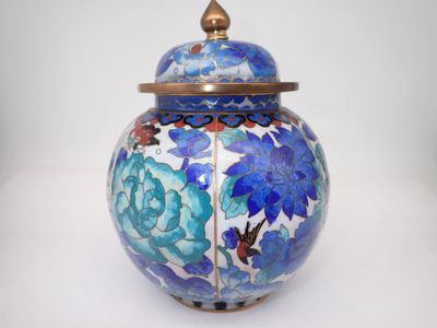 une image représentant un vase bleu et blanc orné de fleurs