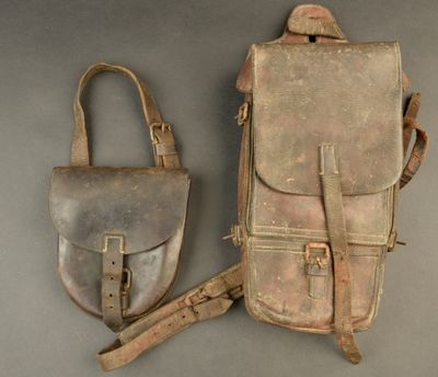 pair of old leather purses sitting on top of a gray surface