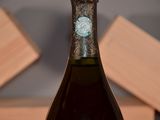 a bottle of wine sitting on a table with a box in the background