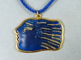 pendentif bleu et or représentant le visage d'une femme, monté sur un cordon bleu
