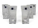 four glasses that are lined up on a white surface