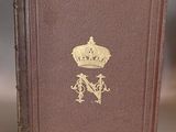 an old book with a crown on top of it sitting on a table