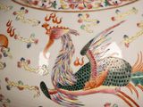 a vase with a bird painted on it sitting on a table