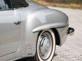 a silver car with a black top parked on the side of the road