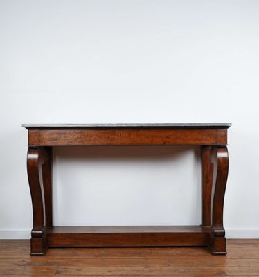 une table en bois avec un plateau en marbre, posée sur un parquet en bois massif