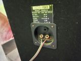 a close up of a black speaker with a white wire