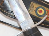 a knife that is laying on top of a leather case