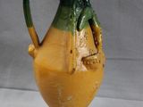 a yellow and green vase sitting on a table