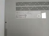 the back of a silver laptop with a small battery on it