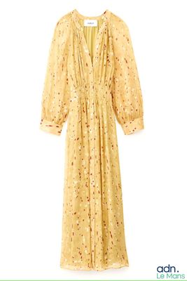 une image représentant une robe jaune suspendue à un cintre sur fond blanc