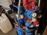 an image of a blue tank with a pressurer and a hose