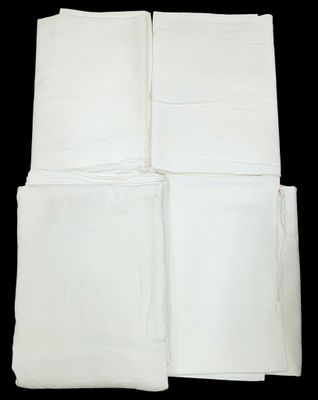 four white napkins are stacked on top of each other on a black background