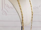 a mannequin with a gold chain on it sitting on a table