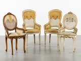 quatre chaises anciennes sont alignées en rangée sur le sol
