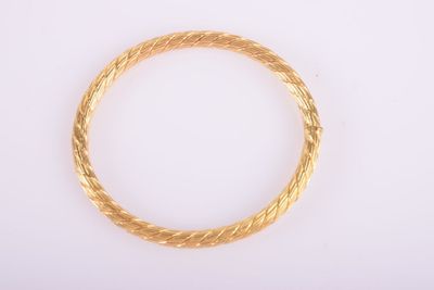 a close up of a gold bracelet on a white surface