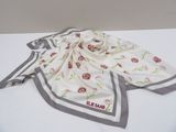 white scarf with red flowers on it on a white surface