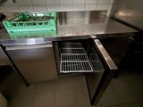 un plan de travail en acier inoxydable avec un panier rempli d'aliments à l'intérieur