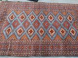 un vieux tapis orné d'un motif bleu et rouge