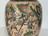 un vase avec un tableau posé sur une table