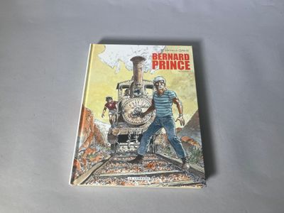 une image représentant un livre sur lequel figure la photo d'un homme debout sur une voie ferrée