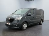 La camionnette grise est garée dans une pièce blanche au sol noir.