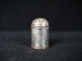 a small silver container sitting on top of a black surface