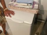 un homme debout à côté d'une machine à laver dans une pièce