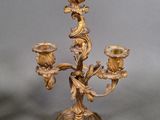 a gold candelab with three candles on top of it