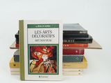 several books are stacked on top of each other on a white surface