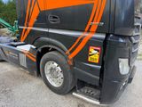 a large semi truck with a flat bed trailer parked on the side of the road