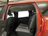 the interior of a red car with the door open and the passenger seat down