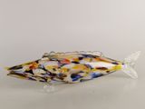 sculpture représentant un poisson en verre jaune et bleu posée sur une surface blanche
