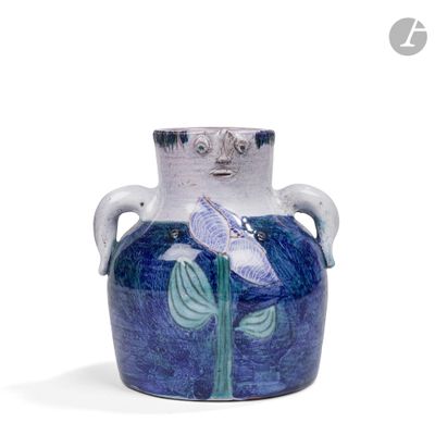 un vase bleu orné d'un oiseau, posé sur une table