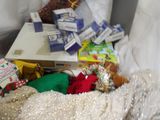a pile of christmas presents on a bed next to a pillow