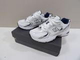 white new balance shoes with blue accents on display on a black box