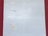 an image of a piece of white paper on a red surface