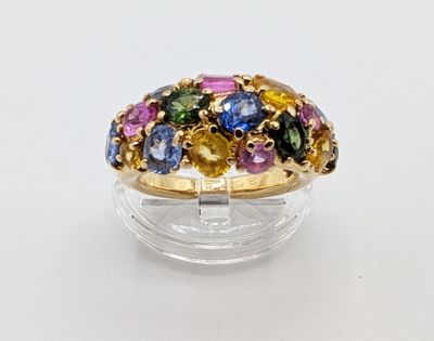 une bague ornée de pierres multicolores sur une surface transparente