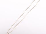 un collier en or orné d'une pièce de monnaie sur fond blanc