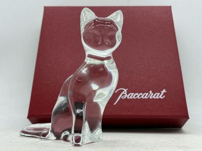 figurine en cristal représentant un chat assis devant une boîte rouge