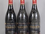 trois bouteilles de vin rouge posées sur une table en verre