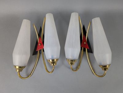 three white and gold wall lights with red accents on them