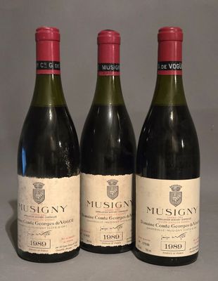 three bottles of wine are lined up on a table