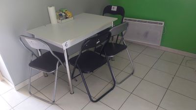 une table et des chaises dans une pièce dont l'un des murs est vert