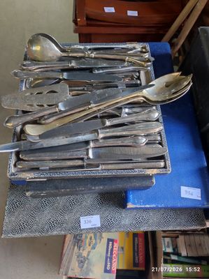 a lot of silverware on a blue cloth
