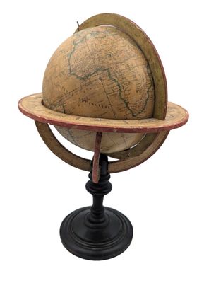 un vieux globe terrestre posé sur un socle, avec un fond blanc