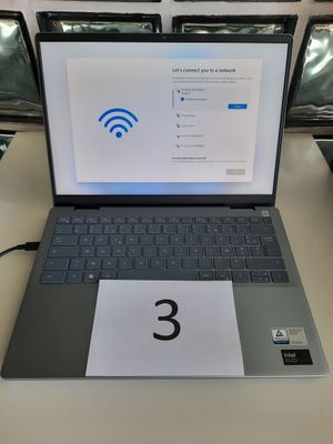 un ordinateur portable posé sur une table sur laquelle figure un numéro