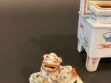 porcelain figurines of a dog and a baby carriage on a table